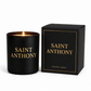 A lit Saint Anthony Prayer Candle sits beside its matching black box with gold "SAINT ANTHONY PRAYER CANDLE" text, offering spiritual comfort and grace.