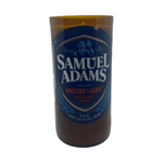 The Recycled Boston Beer Candle is crafted from a brown Samuel Adams Boston Lager bottle with its original blue and white label, transformed into a unique hand-poured candle.