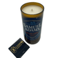 The Recycled Boston Beer Candle, hand-poured in a repurposed Samuel Adams Boston Lager bottle, is displayed beside a black "Custom Candle Co" matchbook.