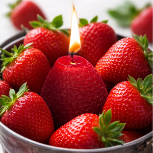 Red strawberry candle among strawberries in a metal bucket