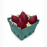 5 Red strawberry-shaped candles in a green cardboard box on a white background
