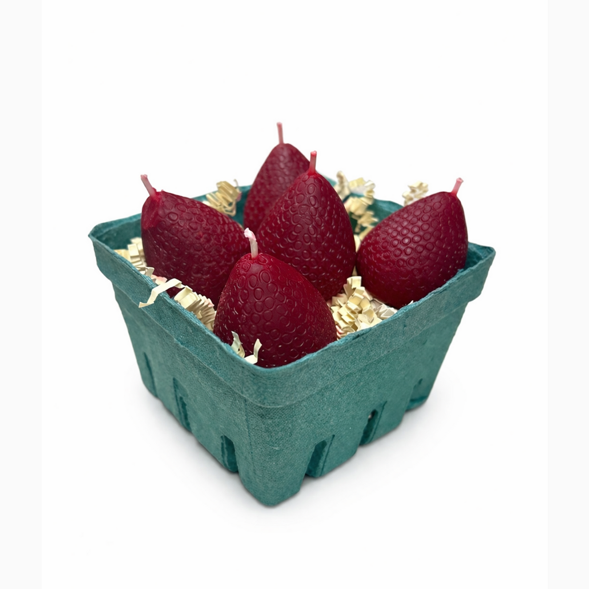 5 Red strawberry-shaped candles in a green cardboard box on a white background