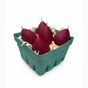 5 Red strawberry-shaped candles in a green cardboard box on a white background