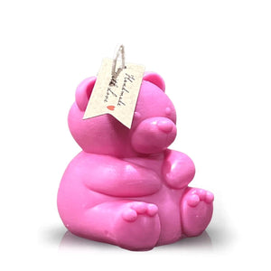 The Teddy Bear Pastel Pink Chubby Candle features a bear with legs out, one paw raised, and a tag on its ear—making it perfect for home decor.