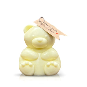 The Teddy Bear Pastel Yellow Chubby Candle is a pale yellow, bear-shaped candle with natural wax and a small brown paper tag on its ear, shown against a white background.