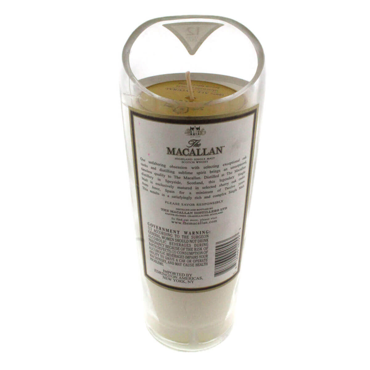 A Recycled Highland Scotch Whiskey Candle in a cylindrical container labeled "The Macallan" with government warning text, featuring a cream-colored candle and visible wick—crafted from upcycled whiskey bottles for eco-friendly appeal.
