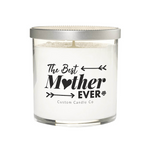 The Best Mother Ever White Glass Candle: a white soy candle in a clear jar with a silver lid, labeled "The Best Mother Ever," "I Love You Mom," and "Custom Candle Co" in black text with decorative arrows.