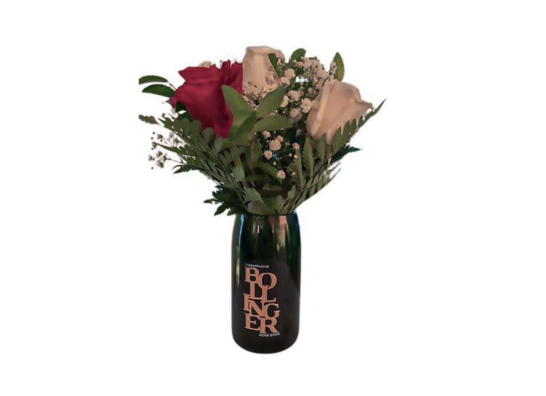 The Valentine Bouquets feature red and white roses with greenery arranged in a repurposed dark Bollinger champagne bottle for an elegant, eco-friendly touch against a white background.