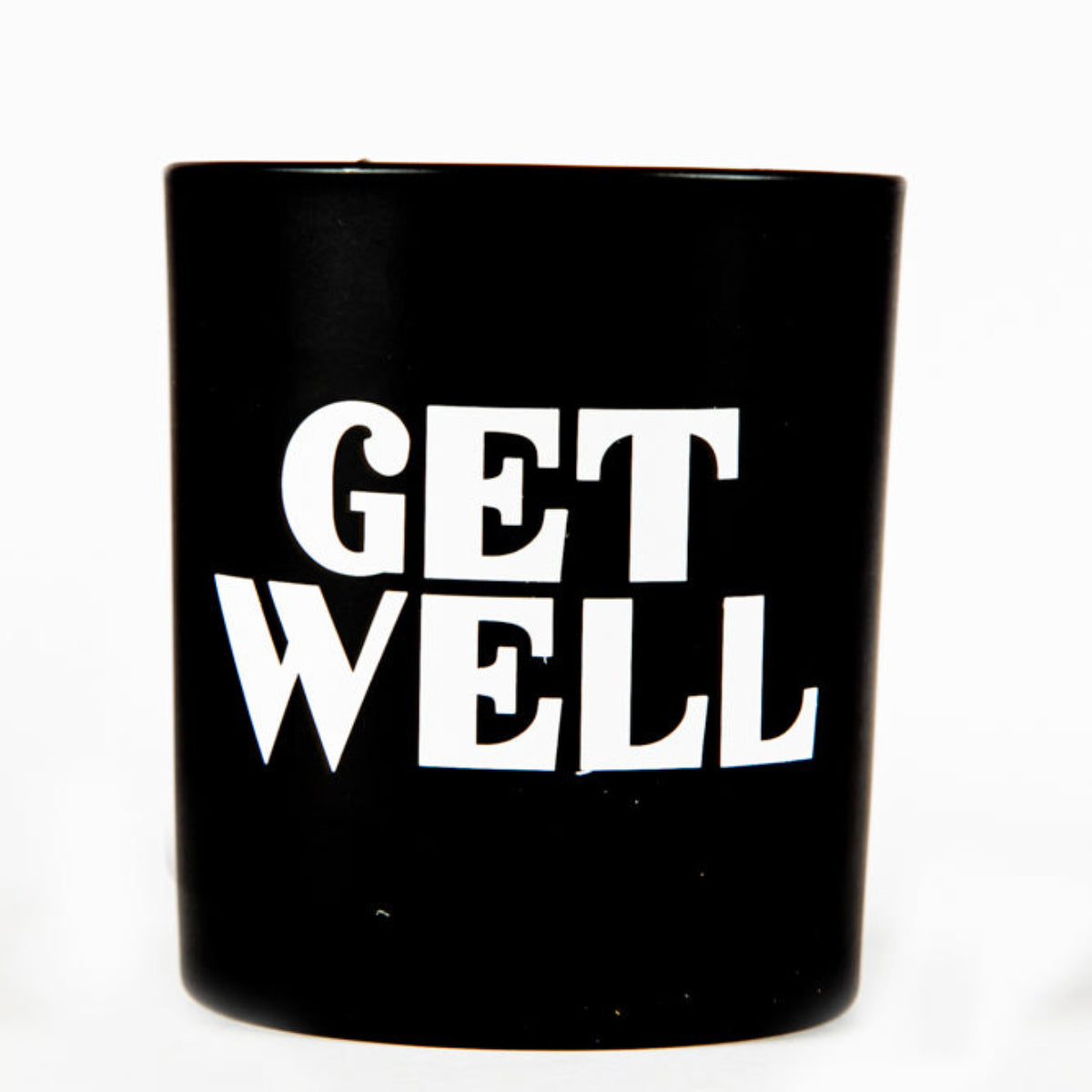 A black Tumbler Candle with "GET WELL" in bold white letters, included in the "Get Well" Candle Gift Box Set—a thoughtful gift for any occasion.