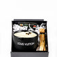 The LV Candle Designer Gift Set includes a black soy wax candle and wooden matches in a sleek black gift box with decorative paper filling.