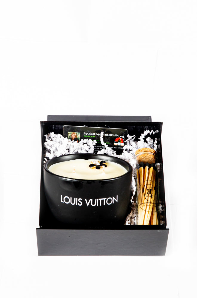 The LV Candle Designer Gift Set includes a black soy wax candle and wooden matches in a sleek black gift box with decorative paper filling.