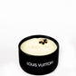 The LV Candle Designer Gift Set features a black soy wax candle with two wicks and a decorative flower on top, shown against a plain white background.