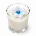 Glass candle with a decorative flower on top against a white background