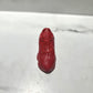 A Y500 – Red Sneaker Candle – Small (On Backorder) is placed on a white surface, casting a shadow to one side.