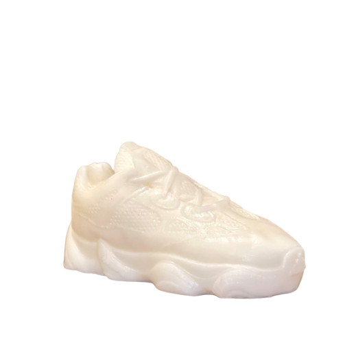 The Y500 – White Sneaker Candle – Small (On Backorder) is a hand-poured, solid wax candle shaped like a classic white sneaker, featuring subtle notes of Black Ice fragrance for a unique and artistic touch.