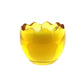 The Yellow Glass Easter Egg is a round, yellow glass candle holder with a wavy, scalloped rim that holds a lit natural wax candle inside.