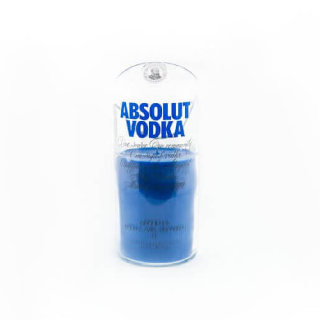 A Recycled Blue Letter Vodka Candle made from a repurposed vodka bottle, featuring blue liquid and the Absolut Vodka logo in blue text on clear glass—an eco-friendly, stylish addition to your décor.