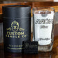 The Recycled Mexican-Style Silver Tequila Candle is displayed in a repurposed Avión Silver Tequila bottle glass, alongside sleek black cylindrical packaging and a business card—highlighting its unique recycled style.