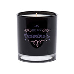 The Be My Valentine’s Quote Candle features a white candle in a black tumbler glass with "Be My Valentine’s" and a romantic quote on the front in decorative lettering.