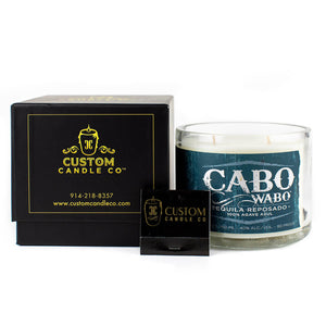 The Recycled Azul Agave Reposado Tequila Candle, crafted from a repurposed tequila bottle, is displayed next to a sleek black Custom Candle Co. box and a matching black accessory.