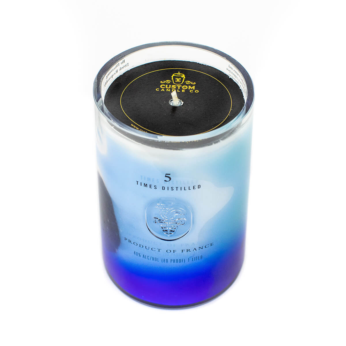 The Recycled Vodka Candle – Multi-color features a glass jar with vibrant hues and a black lid, labeled “Product of France” and “5 Times Distilled”—a unique choice for vodka candle enthusiasts.