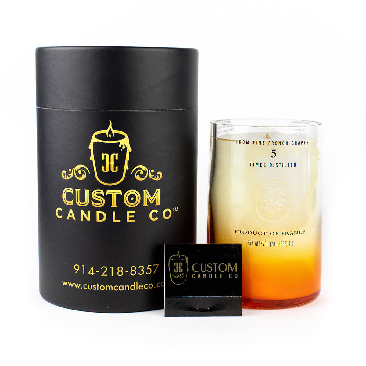 The Recycled Vodka Candle – Multi-color by Custom Candle Co. features a soy candle in a glass vessel with branded packaging and a matchbox, displayed against a white background.