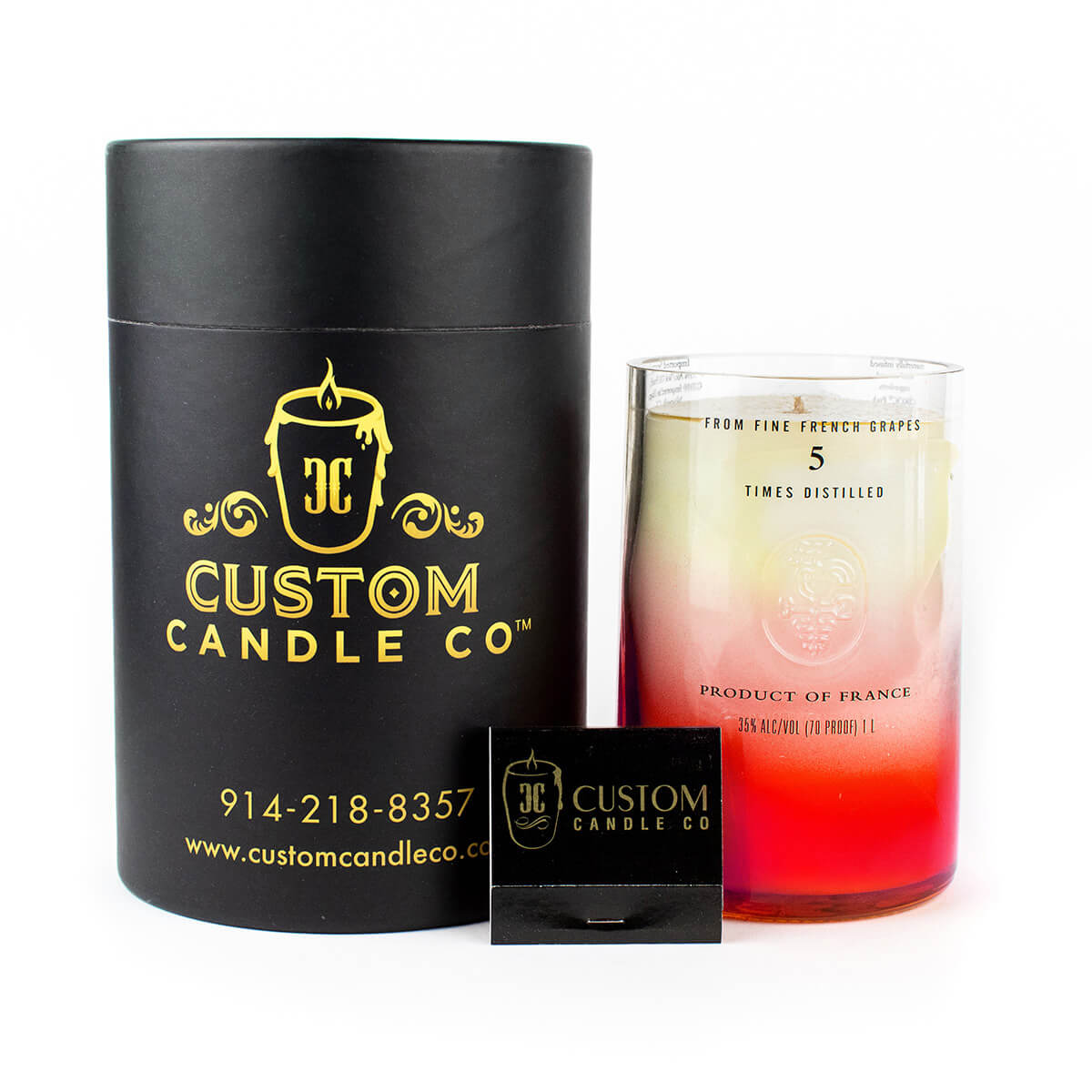 A Recycled Vodka Candle – Multi-color by Custom Candle Co. in gradient pink and white glass, with black cylinder packaging and a branded matchbox displayed in front.