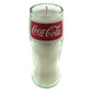 The Recycled Soda Bottle Candle is a hand-poured soy candle set in a clear glass designed to resemble a classic Coca-Cola cup, finished with a red Coca-Cola logo label.