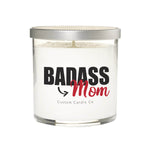 The Badass Mom Candle is a white natural soy candle in a clear glass jar with a silver lid. Its bold label reads "BADASS Mom" and "Custom Candle Co" below—the perfect custom candle gift for Mom.