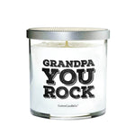 The Grandpa You Rock candle is a white natural soy candle in a clear glass jar with a silver lid, featuring bold black "Grandpa You Rock" text—a perfect custom gift for Dad or Grandpa.