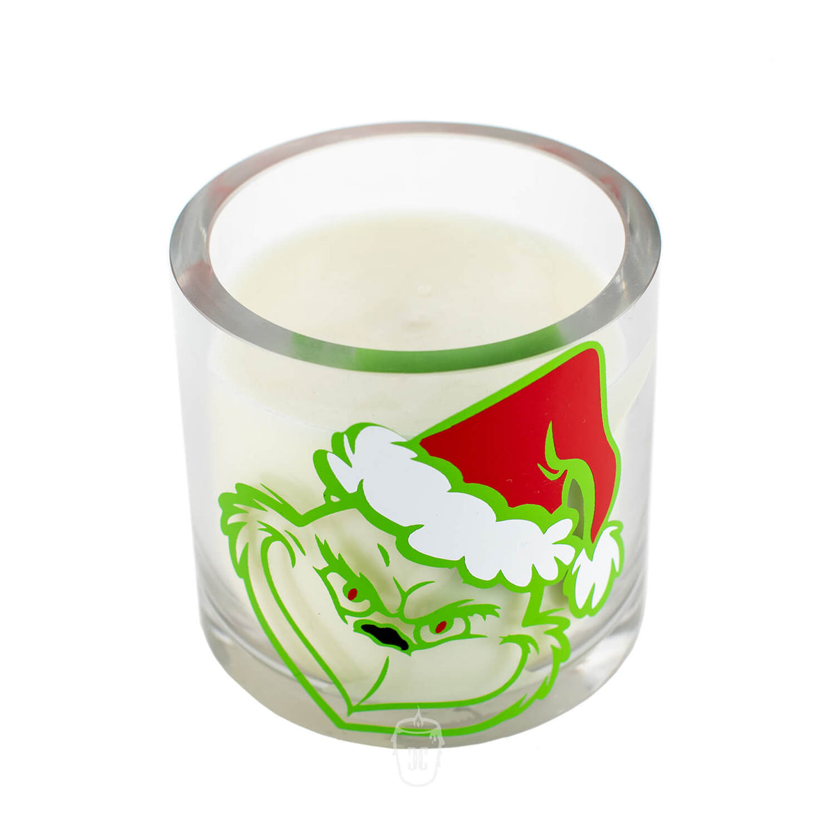 The Grinch Holiday Candle is a natural soy candle in a clear glass holder, featuring the Grinch in a red Santa hat—perfect for brightening up your space this holiday season.