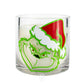The Grinch Holiday Candle is a clear glass with a Grinch illustration in a red Santa hat, filled with a festive natural soy wax Christmas candle.