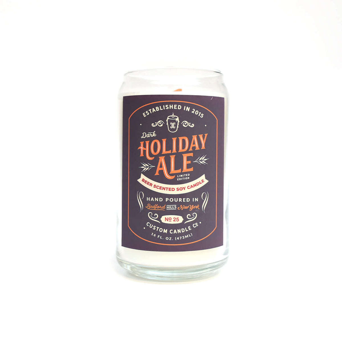 The Dark Holiday Ale Candle is a hand-poured, beer-scented candle crafted from natural soy in a clear glass, featuring a "Dark Holiday Ale" label and designed to look like a classic 12 oz beer can.
