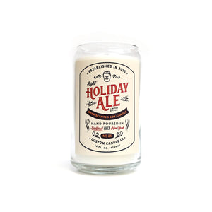 The Light Holiday Ale Candle is a hand poured 16 oz natural soy candle in a glass jar, featuring a vintage-style "Holiday Ale" design on the front.