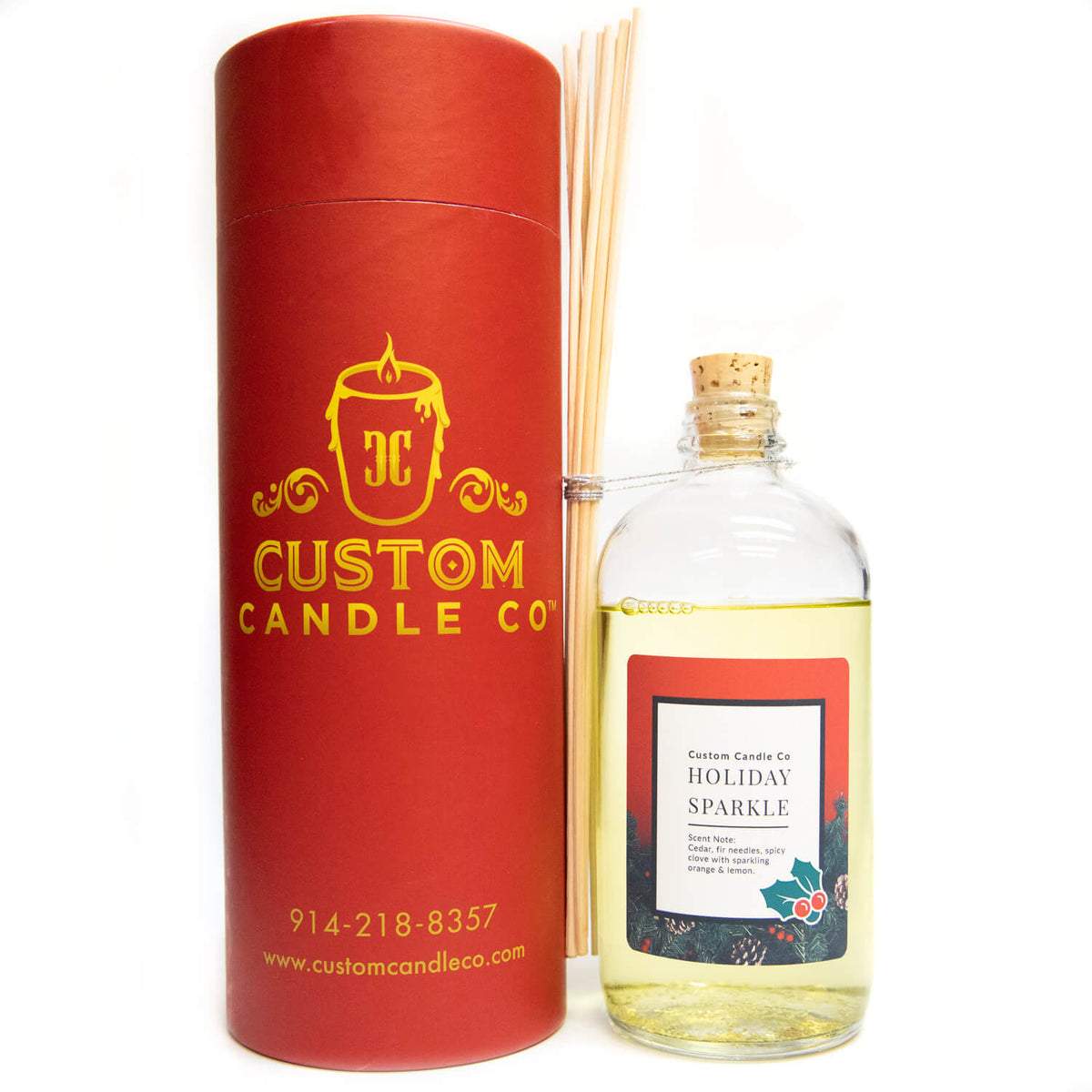 The Musical Holiday Candle & Diffuser | Holiday Sparkle, featuring a festive scent and reed diffuser sticks, is displayed in a red cylindrical container and matching glass bottle against a white background.