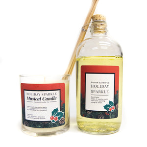 The Musical Holiday Candle & Diffuser | Holiday Sparkle set features a festive candle and reed diffuser with red, holly-adorned labels—perfect for adding seasonal fragrance to your holiday collection.