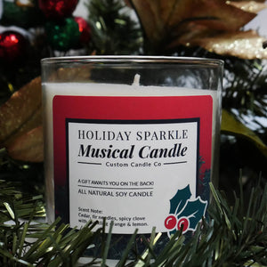 The Musical Holiday Candle – Holiday Sparkle is a glass jar soy candle displayed with festive décor, ideal for anyone who enjoys musical Christmas candles.