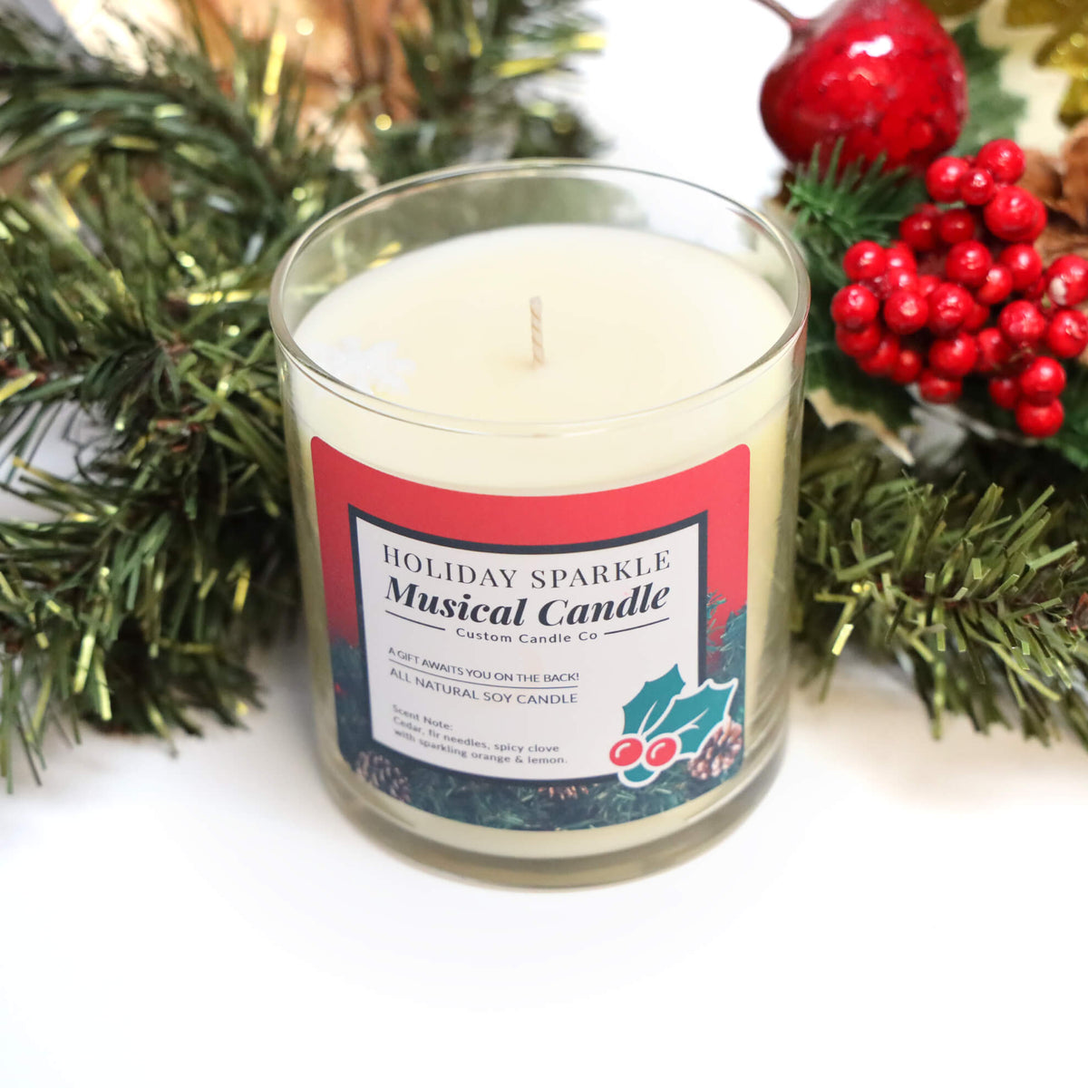 The Musical Holiday Candle & Diffuser | Holiday Sparkle, from our festive Musical Christmas Candles collection, is displayed with pine branches and red berries—an ideal way to bring holiday cheer to your home.