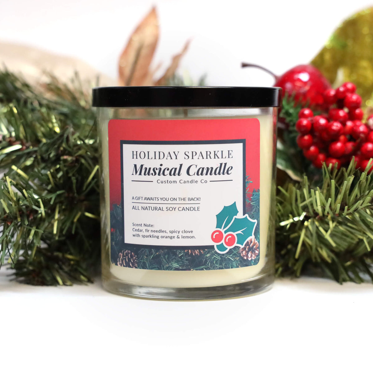The Musical Holiday Candle & Diffuser | Holiday Sparkle features festive decorations, a black lid, and sits among greenery and berries—a delightful scented soy candle perfect for holiday celebrations.
