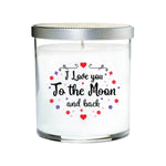 The "I Love You to the Moon and back Quote Candle" features a hand-poured candle in a clear tumbler glass jar, silver lid, and the loving quote on the front, accented with small red and purple decorations.