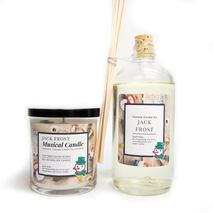 The Musical Holiday Candle & Diffuser | Jack Frost features snowman labels and festive decor—perfect for scented candle fans. Includes a holiday candle and reed diffuser with wooden sticks, set against a white background.