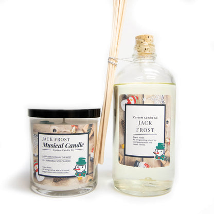 The Musical Holiday Candle & Diffuser | Jack Frost features snowman labels and festive decor—perfect for scented candle fans. Includes a holiday candle and reed diffuser with wooden sticks, set against a white background.