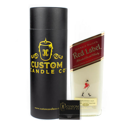 A Custom Candle Co. cylindrical box, business card, and a Recycled Red Label Whiskey Candle in a glass shaped like a Johnnie Walker Red Label bottle.
