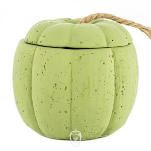 The Green Cement Pumpkin Candle features a pumpkin-shaped green cement container with a lid and a short rope handle, shown on a white background.