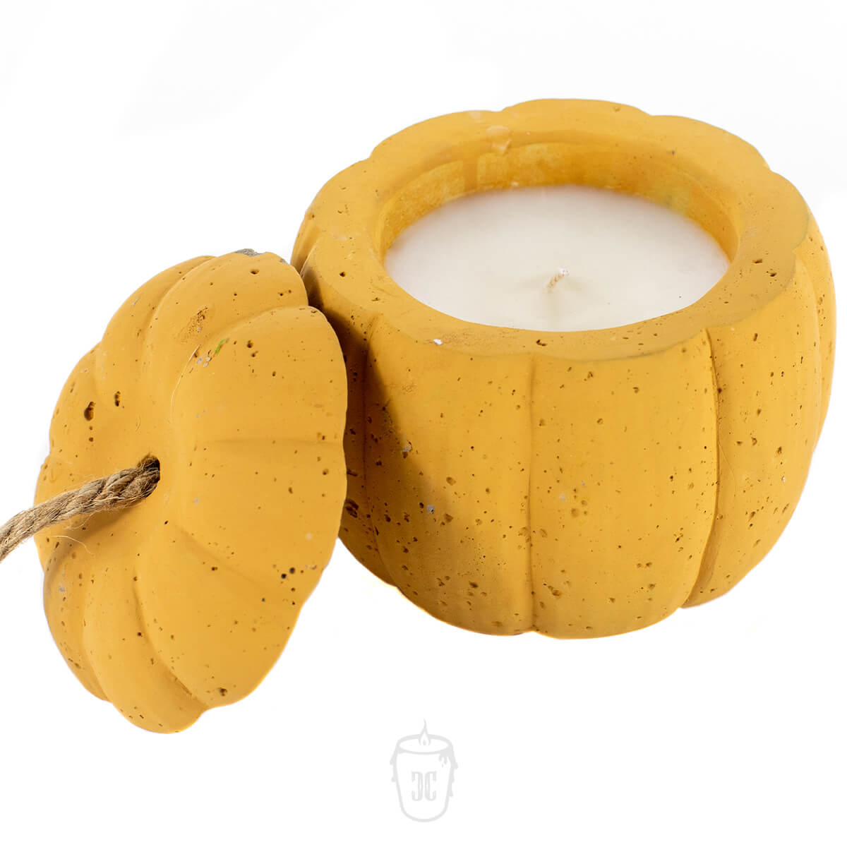 The Yellow Cement Pumpkin Candle features a white candle in a yellow pumpkin-shaped container with a removable lid beside it.
