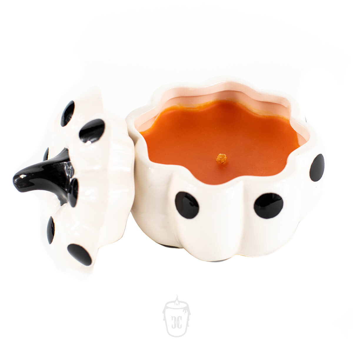 The Ceramic Mini Polka White Pumpkin Candle features an orange scent and comes in a white ceramic pumpkin holder with black dots and a matching lid, making it ideal for cozy autumn decor.