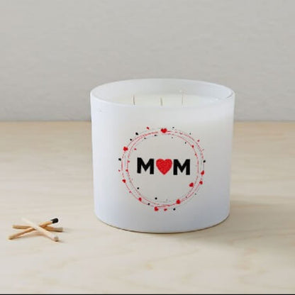 The Mom Quote Candle (Frosted tumbler jar), a hand poured soy wax candle labeled "MOM" with a red heart, sits on light wood next to three wooden matches.