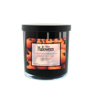 A Musical Halloween Candle – Pumpkin Pancake, in a black jar with a pumpkin-themed label that says "Happy Halloween" and "Pumpkin Pancake All Natural Soy Candle.