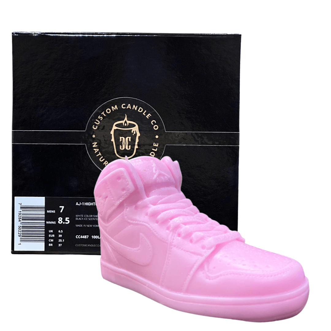 The AJ-1 Baby Pink Sneaker Candle – Large (On Backorder) is shown in front of a black box with Custom Candle Co.’s gold logo, offering a hand-poured candle that brings unique, stylish flair to any space.