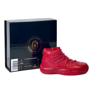 The AJ-11 Red Hightop Sneaker Candle – Large (On Backorder), hand poured from all natural wax, sits beside a black box with sizing and Custom Candle Co. branding.
